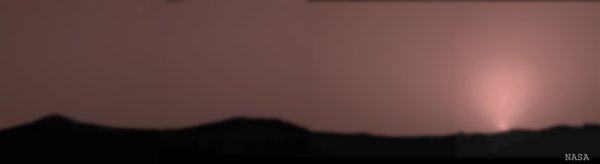 A panoramic view of distant, silhouetted Martian mountians set off by a rose-colored sky at sunset!